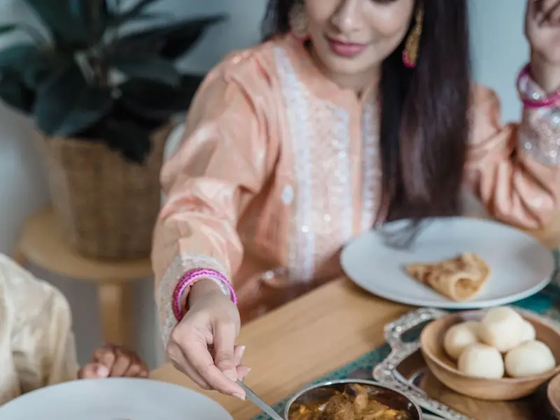 An Indian family sharing a home-cooked meal of roti, dal and sabzi
