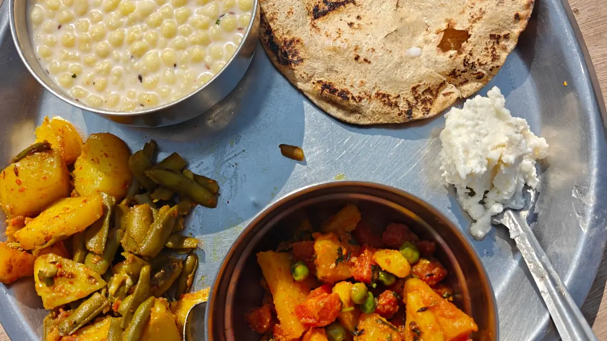 A steel thali with roti, dal, dry sabzi, curd and salad, a PCOS-friendly Indian plate